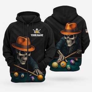 May include: A black zip-up hoodie featuring a graphic of a skeleton wearing an orange fedora and playing billiards. The design includes the text YOUR NAME above the skeleton, with colorful billiard balls on a green table. A small American flag patch is on the sleeve.