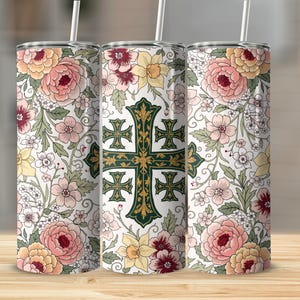 Pode incluir: Três copos com padrão floral com canudos. O design apresenta um padrão repetido de flores rosa, amarelas e pêssego com folhas verdes em um fundo branco. Um copo tem um design de cruz verde.