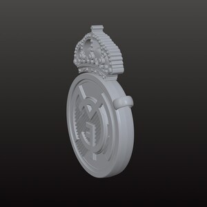 May include: A grey, three-dimensional emblem featuring a crown above a circular design. The circular design has a central graphic and a surrounding ring. The emblem is set against a dark grey background.