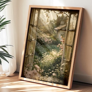 May include: A framed artwork depicts a sunlit garden scene viewed through an open window. The artwork features a wooden frame and showcases a cottage, flowers, and sunlight. A potted plant and sheer curtains are in the foreground.