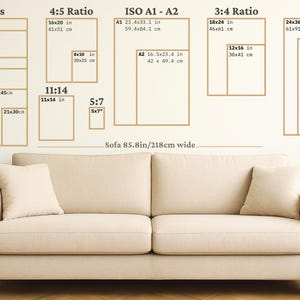 Art print size guide showing cm, ratio and inch sizes displayed above a neutral sofa for visual scale reference.