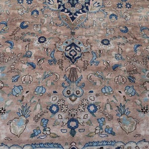 K&ouml;nnte beinhalten: Nahaufnahme eines Teppichs mit floralem Muster. Der Teppich hat einen beigefarbenen Hintergrund mit blauen und cremefarbenen Blumenmotiven. Das Design umfasst stilisierte Blumen und Bl&auml;tter.