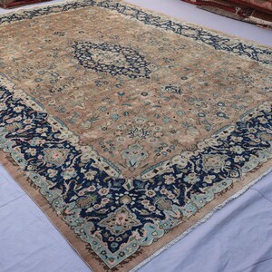K&ouml;nnte beinhalten: Gro&szlig;er, rechteckiger Teppich mit einem aufwendigen Blumenmuster. Der Teppich hat ein zentrales Medaillon in Blau und Beige, umgeben von einem marineblauen Rand mit floralen Mustern. Die Farbgebung des Teppichs ist dezent, was ihm ein Vintage-Aussehen verleiht. Ca. 300 x 200 cm.