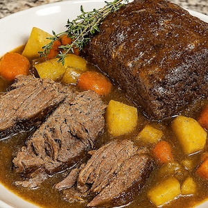 Peut inclure: Un repas copieux avec un grand rôti doré, du bœuf tranché et un assortiment de légumes. Le plat comprend des morceaux de pommes de terre jaunes et de carottes oranges, le tout baignant dans une sauce savoureuse. Des herbes fraîches garnissent le dessus, servi sur une assiette blanche.