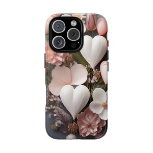 Op de afbeelding: Smartphonehoesje met een bloemenontwerp met witte hartvormen en roze en perzik bloemen. De hoes heeft een donkergrijze achtergrond en een cameramodule.