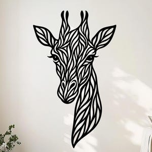May include: A black metal giraffe head wall art piece. The giraffe's head and neck are stylized with intricate, flowing patterns. The artwork is mounted on a white wall, adding a modern touch to the room's decor. The giraffe's eyes are detailed.