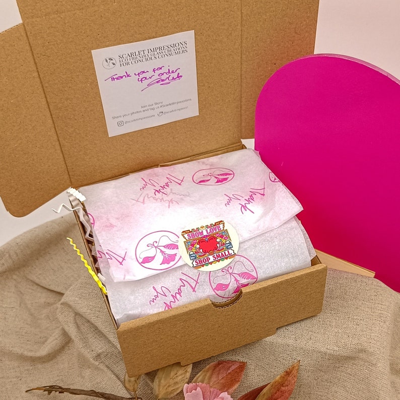 Pode incluir: Uma pequena caixa de cart&atilde;o com um c&iacute;rculo rosa no topo. A caixa est&aacute; aberta e cheia de papel de seda branco. Um adesivo com o texto "Show Love Shop Small" est&aacute; no papel de seda. A caixa tem uma nota escrita &agrave; m&atilde;o que diz "Obrigado pelo seu pedido".