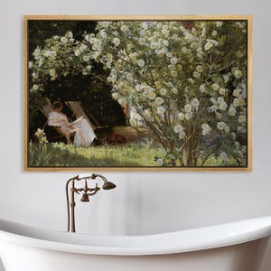 May include: A framed painting depicts a woman in a white dress relaxing in a garden, surrounded by white flowers. The painting hangs above a white clawfoot bathtub with bronze fixtures and a wooden stool.