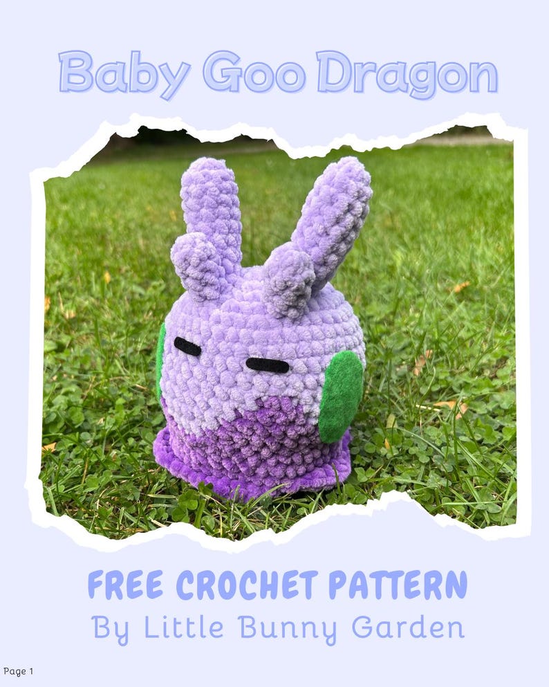 May include: A handmade, plush, lavender-colored Baby Goo Dragon, with green accents and black eyes, sits on grass. The text "Baby Goo Dragon" is above the dragon. Below, the text reads "FREE CROCHET PATTERN By Little Bunny Garden."