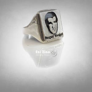 Könnte beinhalten: Ein silberner Ring mit einer quadratischen Oberfläche, die ein Schwarzweißbild eines Männergesichts und den Text "Bugsy Siegel" zeigt.