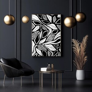 Pode incluir: Impressão de arte abstrata em preto e branco com um design de folhas. A obra de arte é emoldurada e pendurada em uma parede escura. O quarto é decorado com uma cadeira preta, uma mesa pequena e detalhes dourados.