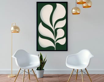 May include: A rectangular wall art piece in a black frame featuring a stylized white leaf pattern on a dark green background. The artwork is displayed on a wall between two white molded chairs with wooden legs, a floor lamp, and hanging lights.