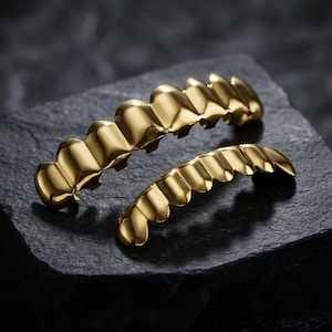 Può includere: Un set di tre tazze in ceramica con finitura opaca e macchiettata. Le tazze sono nei toni del crema, grigio chiaro e grigio scuro. Ogni tazza ha un design semplice e minimalista.