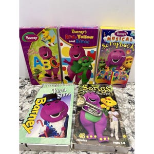 May include: A collection of five Barney the Dinosaur VHS tapes. Titles include "Know My ABCs", "Red, Yellow and Blue", "Musical Scrapbook", "Talent Show", and "Songs From the Park". The tapes feature colorful graphics and the purple dinosaur.