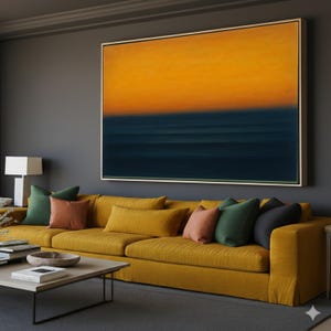 Puede incluir: Una gran pintura abstracta con una sección superior de color amarillo dorado y una sección inferior azul oscuro, enmarcada en madera clara. Un sofá amarillo con varios cojines de colores se encuentra debajo de la pintura. Una mesa de centro de madera está frente al sofá.