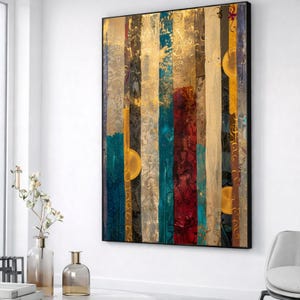 May include: Abstract art piece with vertical stripes in various colors, including gold, blue, red, and beige. The artwork features textured patterns and circular gold accents, framed in a black border. The piece is displayed on a white wall.