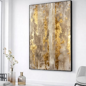 Puede incluir: Impresión artística abstracta con marco negro. La obra presenta una superficie texturizada con vetas verticales doradas y tonos neutros de gris y beige. La pintura tiene una estética moderna y minimalista.