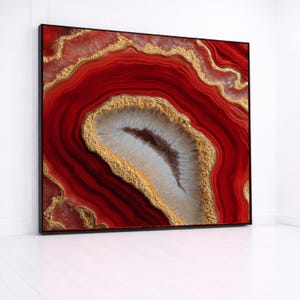 Puede incluir: Una pieza de arte mural rectangular que presenta un patrón de piedra ágata roja vibrante con capas concéntricas de carmesí profundo y blanco translúcido. El diseño está acentuado por vetas metálicas doradas y texturizadas.