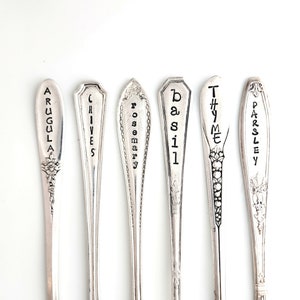 May include: Six silver spoons with engraved names of herbs: Arugula, Chives, Rosemary, Basil, Thyme, and Parsley.