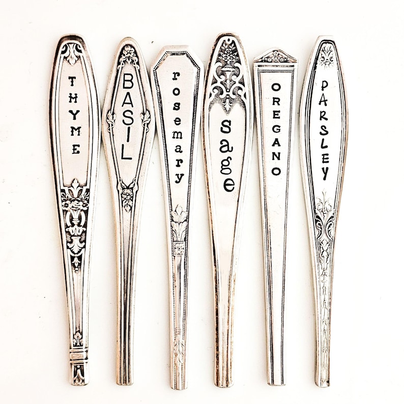 May include: Six silver spoons with black lettering, each labeled with a different herb: Thyme, Basil, Rosemary, Sage, Oregano, and Parsley.