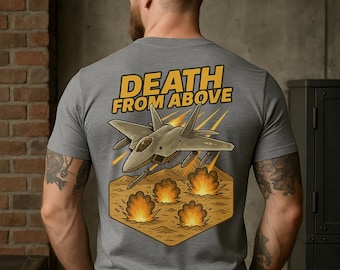 May include: Gray t-shirt with a graphic design featuring a fighter jet and the words "DEATH FROM ABOVE" in yellow. The design includes explosions and a hexagonal shape.