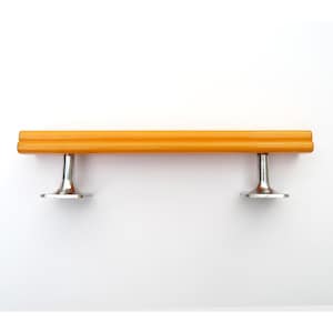 May include: A horizontal cabinet pull handle featuring a long, rectangular, bright orange bar with a subtle grooved texture. The bar is supported by two polished silver-toned metal pedestals that flare outward at the base for mounting.