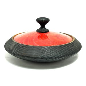 May include: A white ceramic mug with a black handle and the text "But First, Coffee" in a black, bold font. The mug is on a white surface.