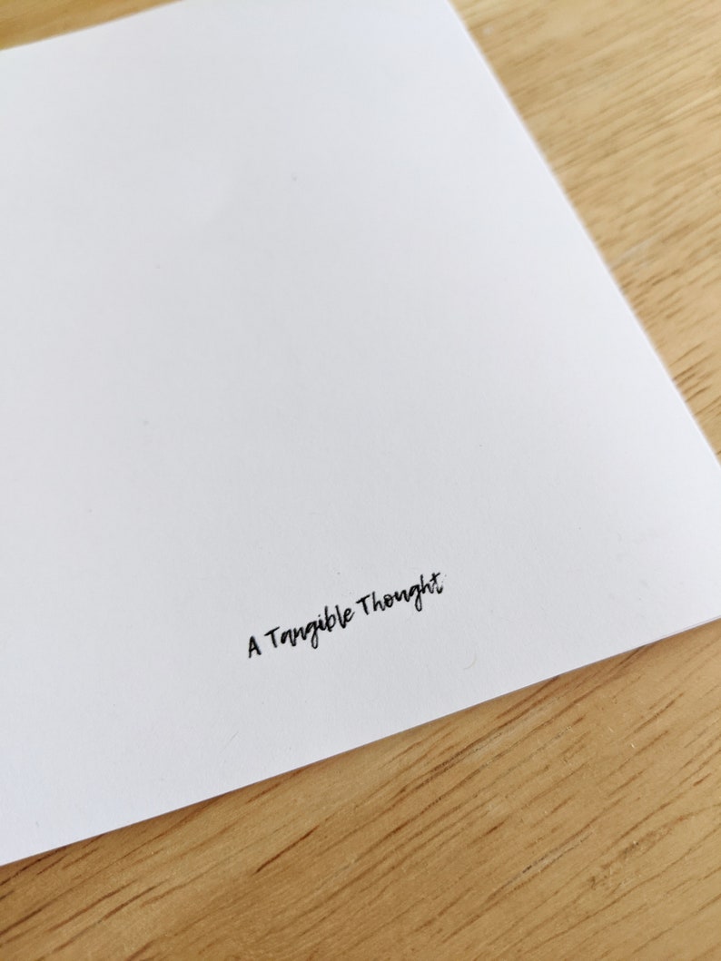 May include: A white card with the text "A Tangible Thought" printed in black ink.