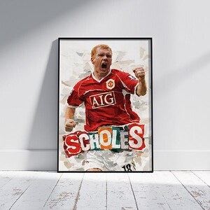 May include: Framed art print featuring a watercolor-style illustration of a soccer player in a red jersey with the AIG logo. The player is celebrating with a fist raised. The word "SCHOLES" is displayed in large letters below the player.