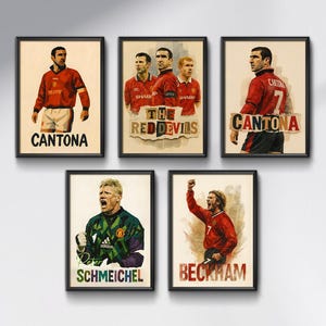 Könnte beinhalten: Fünf gerahmte Kunstdrucke mit Fußballspielern in Aktion. Die Drucke zeigen Spieler in roten Trikots mit Namen wie "CANTONA", "BECKHAM" und "SCHMEICHEL". Ein Druck lautet "THE RED DEVILS". Der Kunststil ist ein Aquarelleffekt.