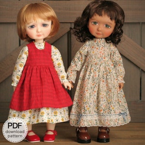 May include: Two dolls wearing dresses. The doll on the left is wearing a red and white plaid dress over a white dress with a floral pattern. The doll on the right is wearing a white dress with a floral pattern. Both dolls are wearing black shoes.