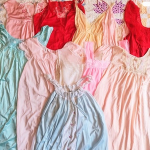 May include: A collection of ten vintage nightgowns in various pastel colors, including pink, blue, and yellow. The gowns are made of delicate lace and silky fabrics.