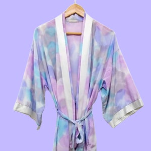 May include: A soft, light blue, pink, and purple tie-dye robe with a white satin trim and a matching tie belt.
