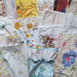 May include: A collection of vintage fabric scraps in various patterns and colors, including floral, geometric, and abstract designs. The fabrics are mostly white with accents of pink, blue, yellow, and green. Some of the fabrics have lace trim.