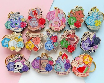 May include: A set of 12 wooden keychains featuring different Dungeons and Dragons character classes. Each keychain has a 20-sided die, a character icon, and floral accents. The classes include Barbarian, Bard, Cleric, Druid, Fighter, Monk, Paladin, Ranger, Rogue, Sorcerer, Warlock, and Wizard.