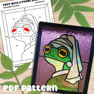 Puede incluir: Un patrón de vitral de una rana con un pendiente de perla. La rana es verde con ojos amarillos y una cubierta de cabeza blanca. El fondo es un patrón de remolino púrpura y blanco. El patrón está etiquetado como "PDF Pattern".