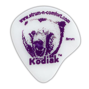 May include: A white guitar pick with a purple bear graphic and the word "Kodiak". The text "www.strum-n-comfort.com" is printed above the bear. The pick is .8mm thick.
