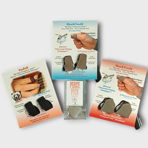 May include: An assortment of guitar picks and accessories, including the SharkTooth and Kodiak brands. The packaging features images of hands using the picks, with text highlighting features and benefits. A Peace Pick is also included.