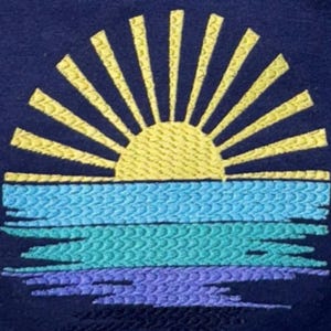 a close-up view of a vibrant embroidered design depicting a sun with rays radiating outwards from a central point, set against a backdrop of blue and purple hues.