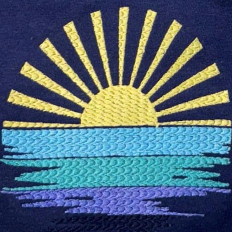 a close-up view of a vibrant embroidered design depicting a sun with rays radiating outwards from a central point, set against a backdrop of blue and purple hues.