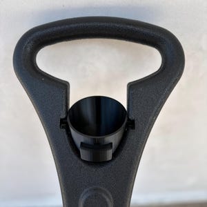 May include: Black plastic handle with a black plastic funnel attached. The handle has a D-shaped opening.