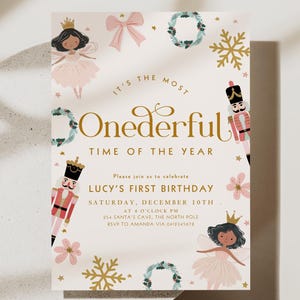 Può includere: Invito rettangolare color crema con il testo "It's the Most Onederful Time of the Year". Ornato con illustrazioni di una fata, schiaccianoci, fiocchi di neve e ghirlande. L'invito è per il primo compleanno di Lucy.