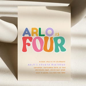 Peut inclure: Une invitation crème avec le texte "ARLO IS FOUR" en lettres colorées et audacieuses. L'invitation comprend les détails d'une célébration du quatrième anniversaire, y compris la date, l'heure et le lieu.