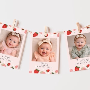 Puede incluir: Un banner de fotos de hitos para bebés con tres fotos, cada una con un bebé con un lazo. Las fotos están decoradas con fresas y las palabras "One Month Old", "Two Months Old" y "Three Months Old".