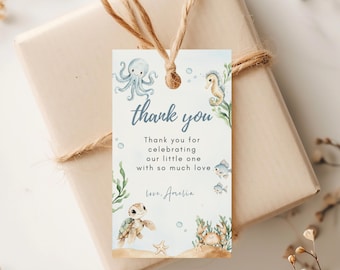 May include: A gift tag with a watercolor design featuring an octopus, seahorse, turtle, and crab. The tag says "thank you" and includes the message "Thank you for celebrating our little one with so much love." The tag is tied to a wrapped gift.
