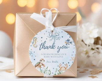 May include: A wrapped gift with a round tag that says "thank you" in blue script. The tag features watercolor illustrations of sea creatures like a seahorse, octopus, fish, turtle, and crab. A white ribbon is tied to the gift.