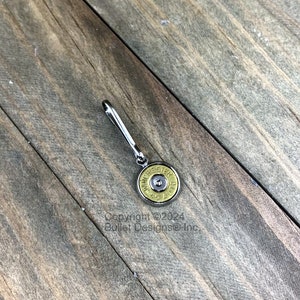May include: A silver keychain with a gold-colored bullet casing charm. The casing has the text "WINCHESTER 45 AUTO" printed on it.