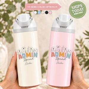 May include: Two cylindrical water bottles with white flip-top lids. The left bottle is cream, the right is light pink. Both feature a floral line art graphic above the text ADMIN Squad and the name Elida in a script font.