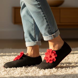 Romantic coquette wool slippers for women in black with red felt flowers, shown in cozy lifestyle wear. Handmade felt house shoes solve cold floor discomfort and make a perfect Valentine’s or Christmas gift for wife or girlfriend.