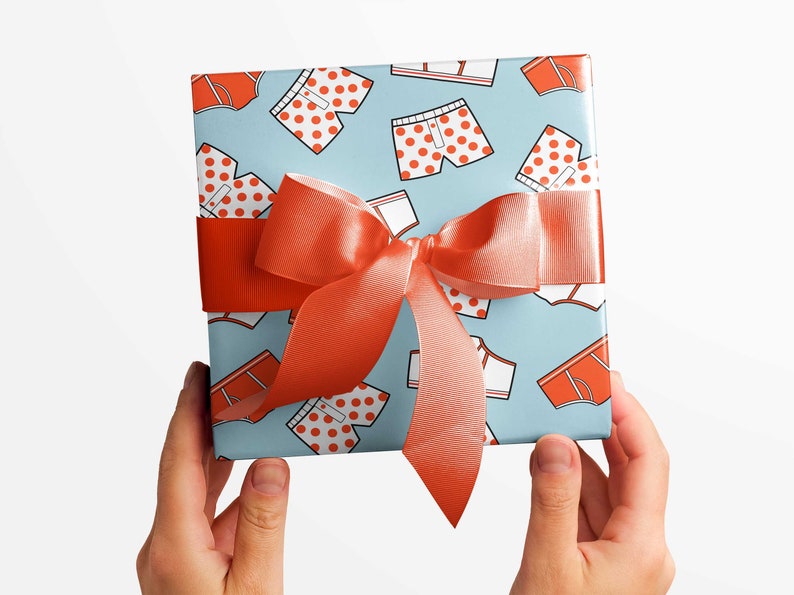 Wrapped gift featuring funny underwear themed wrapping paper with red and white polka dot boxers and briefs design.